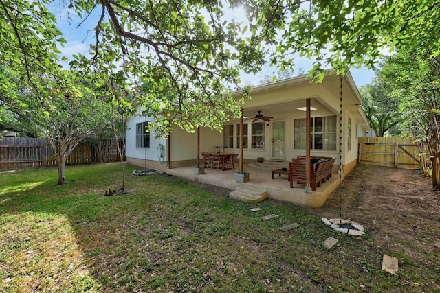 rear view of property with a ceiling fan and a patio