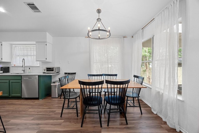 dining space with dark wood finished floors and a chandelier