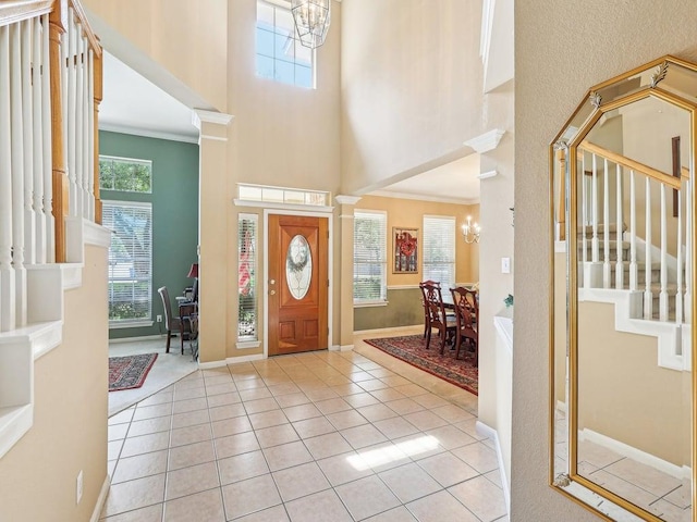 14928 Thatcher Dr, Austin, TX 78717 - entryway with a towering ceiling, a chandelier, stairs, light tile patterned flooring, and ornamental molding