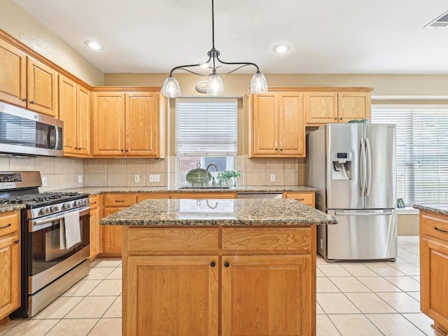 14928 Thatcher Dr, Austin, TX 78717 - kitchen with stainless steel appliances, plenty of natural light, light tile patterned floors, a kitchen island, and recessed lighting