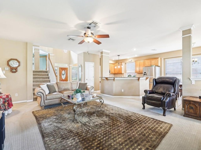 14928 Thatcher Dr, Austin, TX 78717 - living room with light colored carpet, ceiling fan, decorative columns, and stairway