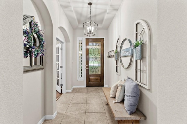 240 Maeves Way, Austin, TX 78737 - foyer entrance featuring a chandelier, light tile patterned flooring, a textured wall, and baseboards