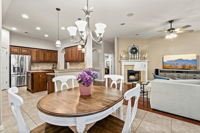 240 Maeves Way, Austin, TX 78737 - dining room featuring light tile patterned flooring, a tiled fireplace, a ceiling fan, recessed lighting, and a chandelier