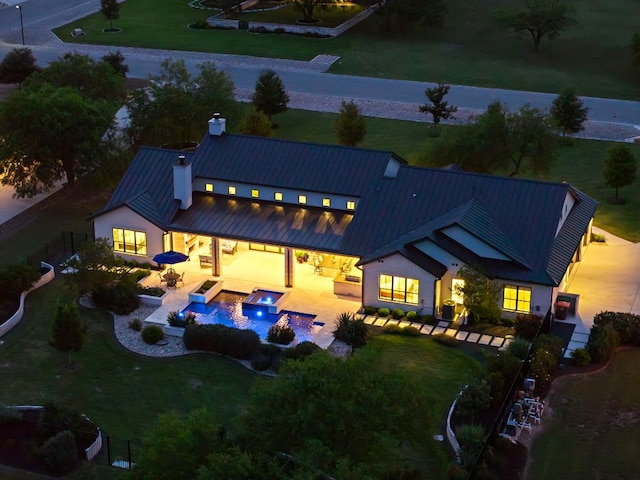811 Wade Rd, New Braunfels, TX 78132 - rear view of house featuring a standing seam roof, a chimney, an outdoor fire pit, and metal roof