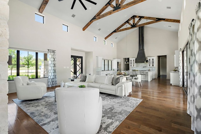 living room with high vaulted ceiling, a ceiling fan, beam ceiling, and dark wood-style flooring