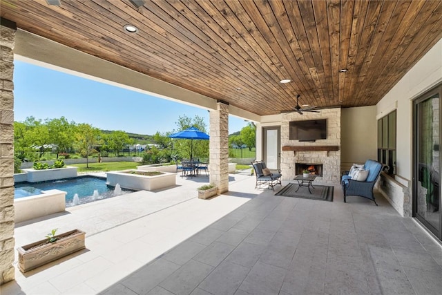 811 Wade Rd, New Braunfels, TX 78132 - view of patio / terrace with an outdoor stone fireplace, an in-ground hot tub, ceiling fan, and an outdoor pool