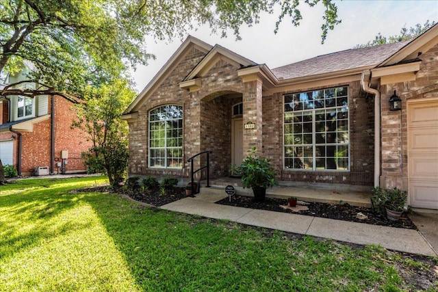 view of front of home with a front lawn and brick siding