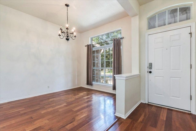 foyer entrance with a chandelier, wood finished floors, and baseboards