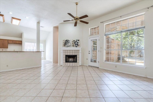 1302 Roadrunner Dr, Cedar Park, TX 78613 - unfurnished living room with light tile patterned floors, a ceiling fan, a tiled fireplace, baseboards, and vaulted ceiling