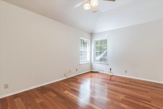 spare room with wood finished floors, ceiling fan, vaulted ceiling, and baseboards