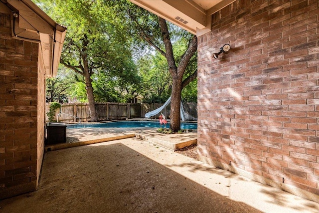 view of pool featuring a water slide and a fenced backyard
