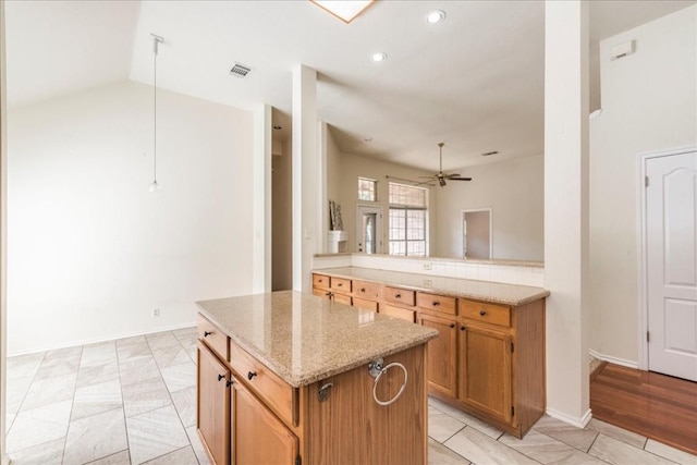 1302 Roadrunner Dr, Cedar Park, TX 78613 - kitchen with a ceiling fan, a kitchen island, light stone counters, lofted ceiling, and recessed lighting