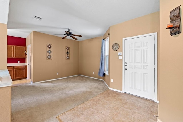 entryway with a ceiling fan, baseboards, and light colored carpet