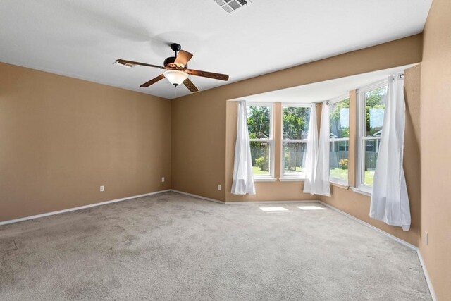 spare room with carpet, ceiling fan, and baseboards