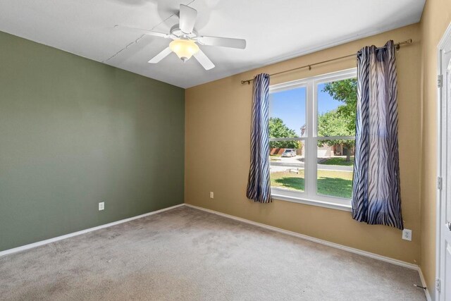 empty room with carpet, a ceiling fan, healthy amount of natural light, and baseboards