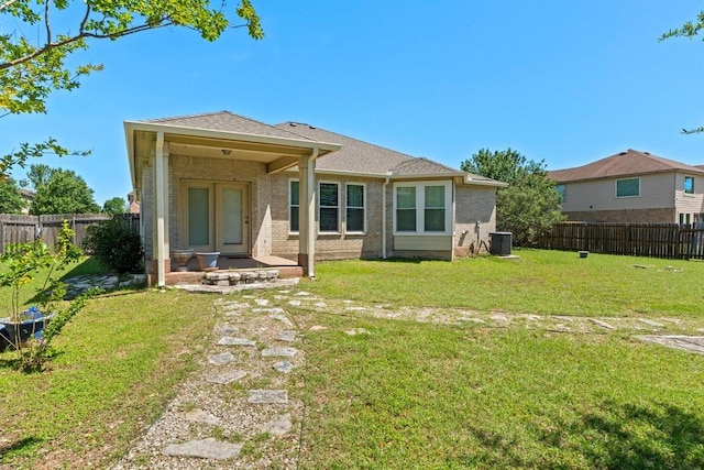 rear view of property with brick siding and central AC