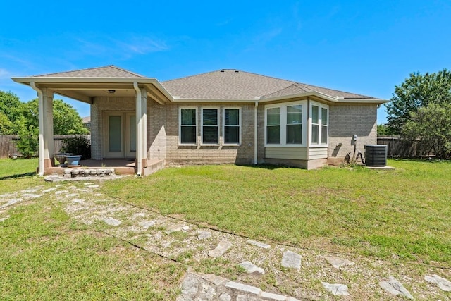 109 Silver Lace Ln, Round Rock, TX 78664 - rear view of property featuring central AC, brick siding, and roof with shingles