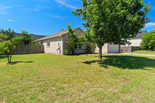 view of yard featuring driveway and a garage
