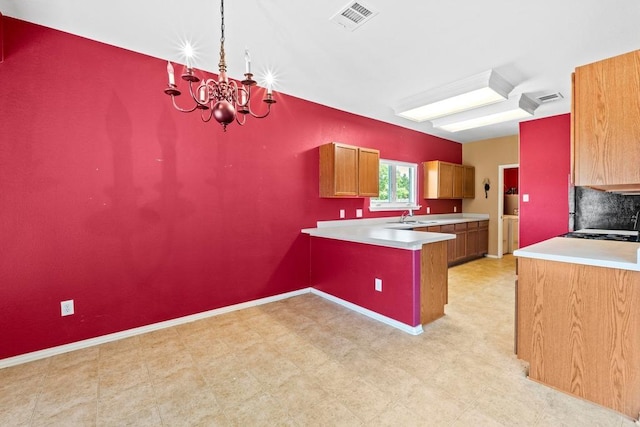 109 Silver Lace Ln, Round Rock, TX 78664 - kitchen with a peninsula, a sink, light countertops, a chandelier, and light floors