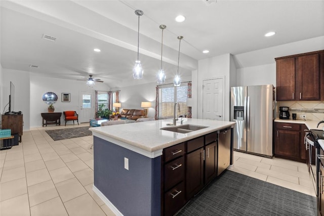 kitchen featuring appliances with stainless steel finishes, a sink, light countertops, light tile patterned flooring, and recessed lighting