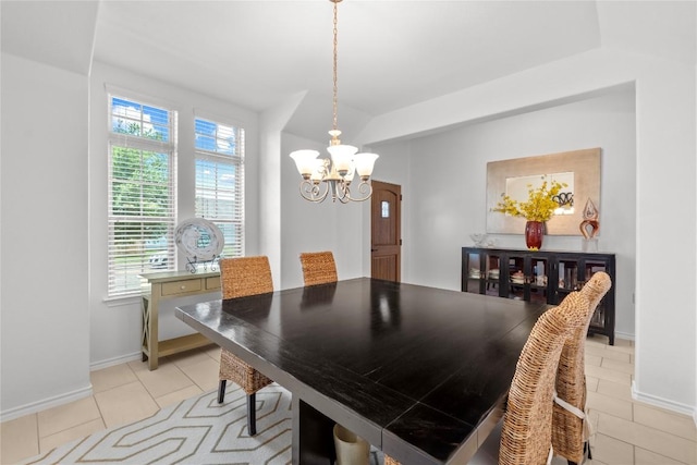 dining room with a chandelier, light tile patterned floors, and baseboards