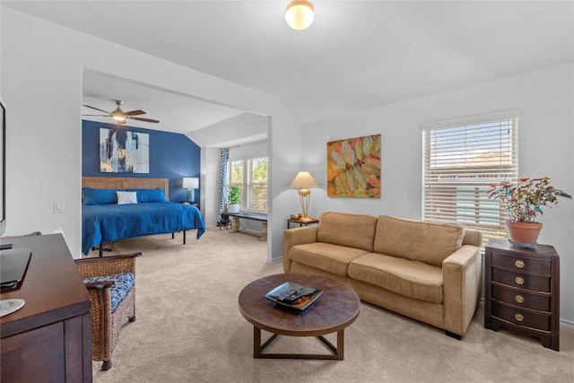 bedroom featuring light carpet, vaulted ceiling, and a ceiling fan