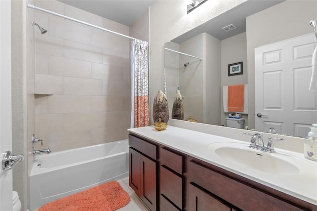 bathroom featuring toilet, shower / bath combo with shower curtain, vanity, and tile patterned floors