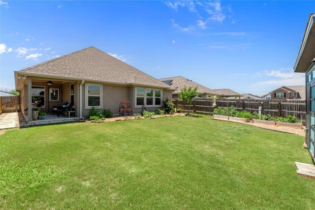 back of property with a garden, roof with shingles, stucco siding, and a patio area