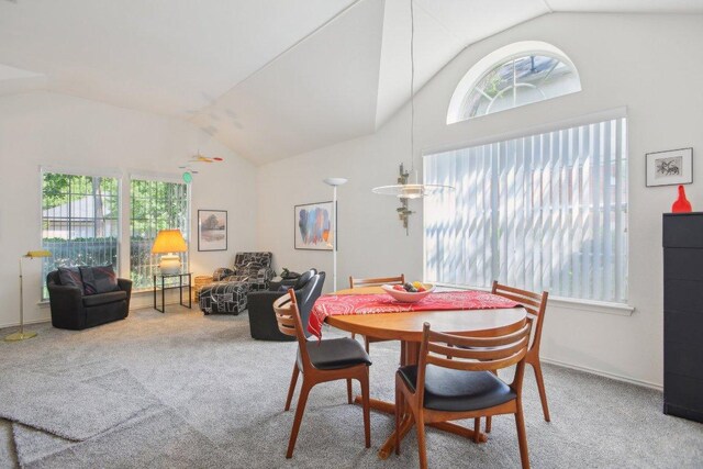 dining room with vaulted ceiling and carpet flooring