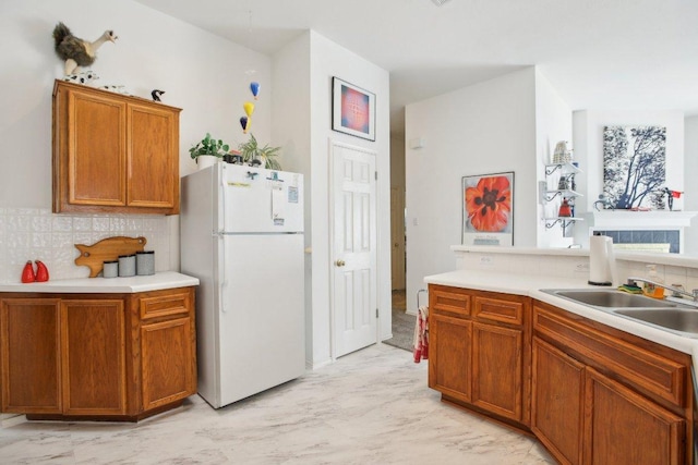 3933 Kristencreek Ln, Round Rock, TX 78681 - kitchen featuring freestanding refrigerator, decorative backsplash, light countertops, and brown cabinetry