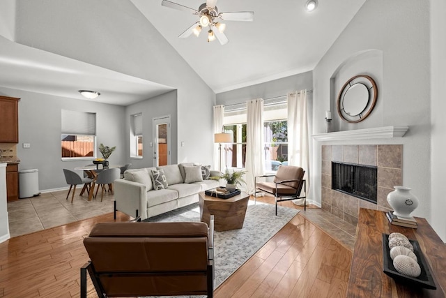 426 Valona Loop, Round Rock, TX 78681 - living room with light wood-type flooring, high vaulted ceiling, ceiling fan, and a tiled fireplace