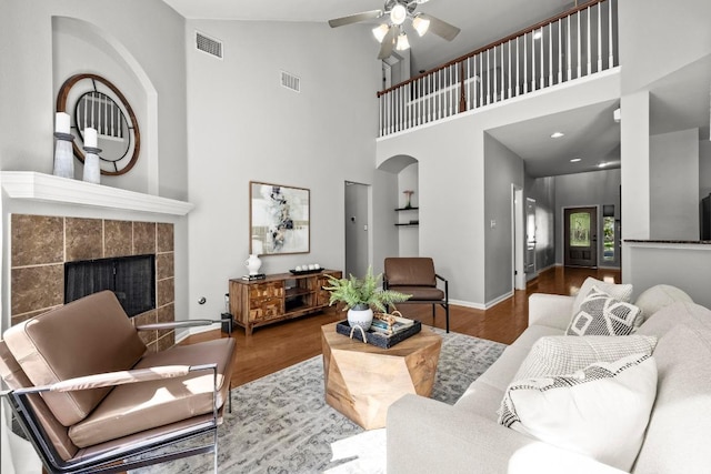 426 Valona Loop, Round Rock, TX 78681 - living area featuring wood finished floors, ceiling fan, a fireplace, high vaulted ceiling, and arched walkways
