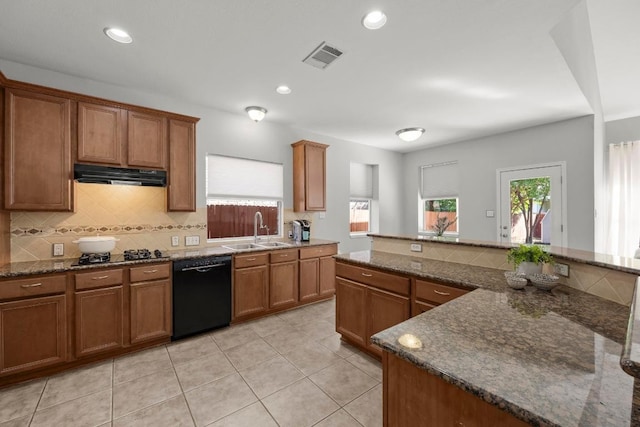 kitchen featuring black appliances, a sink, exhaust hood, brown cabinetry, and tasteful backsplash