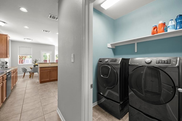 426 Valona Loop, Round Rock, TX 78681 - laundry room with washing machine and clothes dryer, light tile patterned floors, and recessed lighting