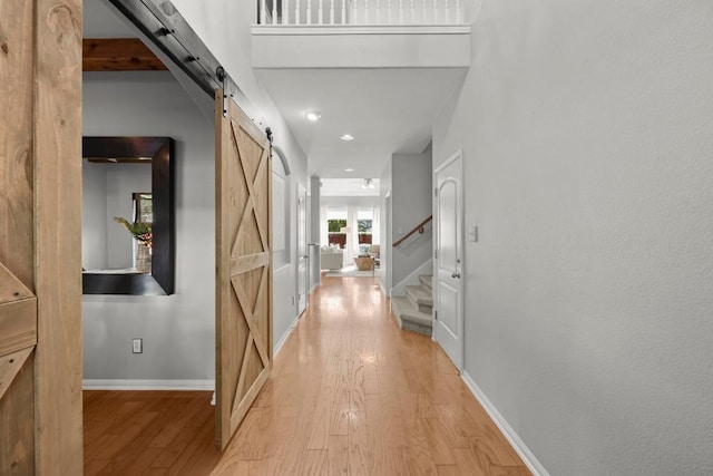 426 Valona Loop, Round Rock, TX 78681 - corridor with a barn door, light wood-style floors, stairs, and recessed lighting