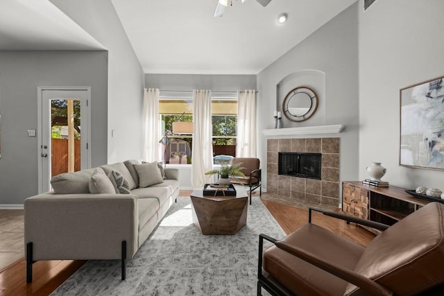 426 Valona Loop, Round Rock, TX 78681 - living room with lofted ceiling, a tiled fireplace, plenty of natural light, ceiling fan, and wood finished floors