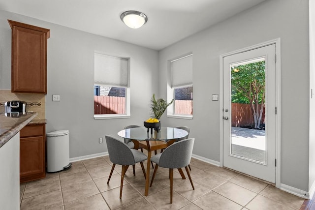 dining space with light tile patterned flooring and baseboards