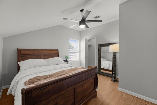 426 Valona Loop, Round Rock, TX 78681 - bedroom with light wood-style floors, lofted ceiling, a ceiling fan, and a walk in closet