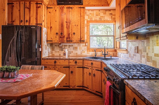 914 Sand Hills Rd, Red Rock, TX 78662 - kitchen featuring freestanding refrigerator, stainless steel microwave, gas range, a sink, and brown cabinetry