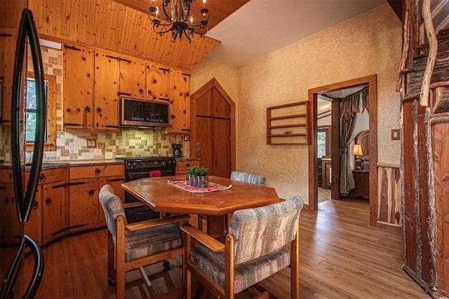 914 Sand Hills Rd, Red Rock, TX 78662 - dining room with light wood-style flooring, a chandelier, healthy amount of natural light, vaulted ceiling, and arched walkways