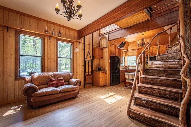 914 Sand Hills Rd, Red Rock, TX 78662 - living area with a chandelier, stairway, wood walls, light wood-type flooring, and beam ceiling
