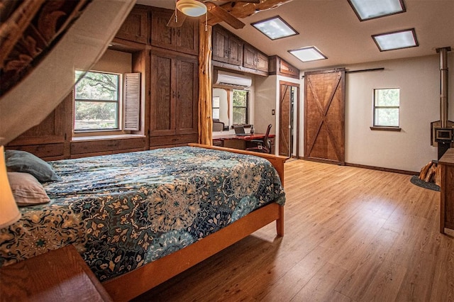 914 Sand Hills Rd, Red Rock, TX 78662 - bedroom with an AC wall unit, light wood-style flooring, vaulted ceiling, and baseboards