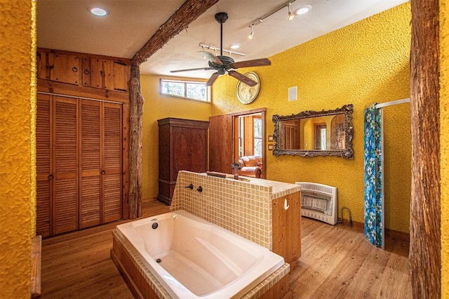914 Sand Hills Rd, Red Rock, TX 78662 - full bath with heating unit, wood finished floors, ceiling fan, and a garden tub