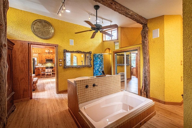 914 Sand Hills Rd, Red Rock, TX 78662 - full bathroom featuring wood finished floors, a garden tub, a ceiling fan, baseboards, and a textured wall