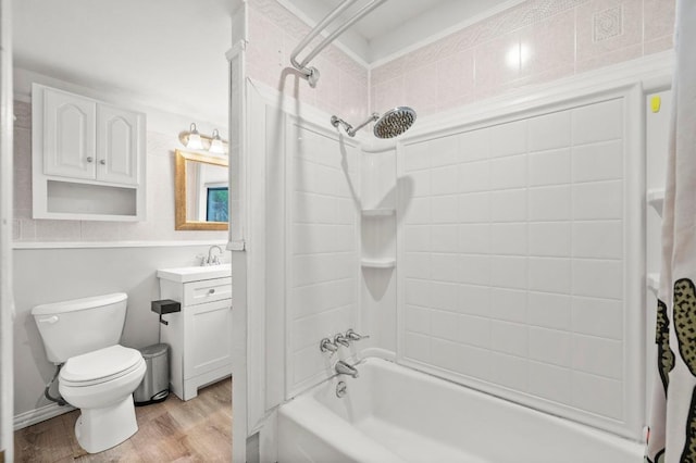full bath with washtub / shower combination, toilet, vanity, and wood finished floors