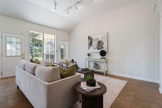living area with rail lighting, vaulted ceiling, and baseboards