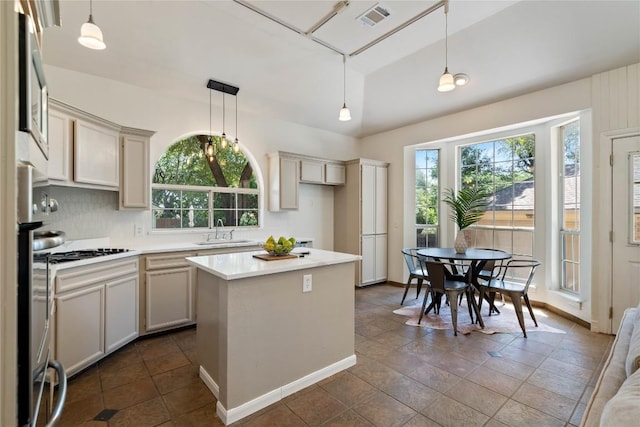 kitchen featuring a sink, healthy amount of natural light, light countertops, and cooktop