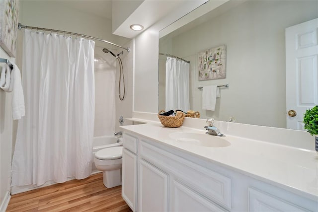 full bath with toilet, vanity, wood finished floors, and shower / bath combo