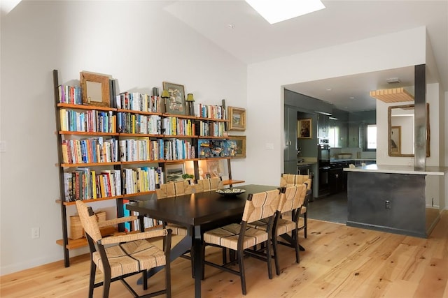 4504 Erin Ln, Austin, TX 78756 - dining area featuring light wood-style flooring, a skylight, and lofted ceiling