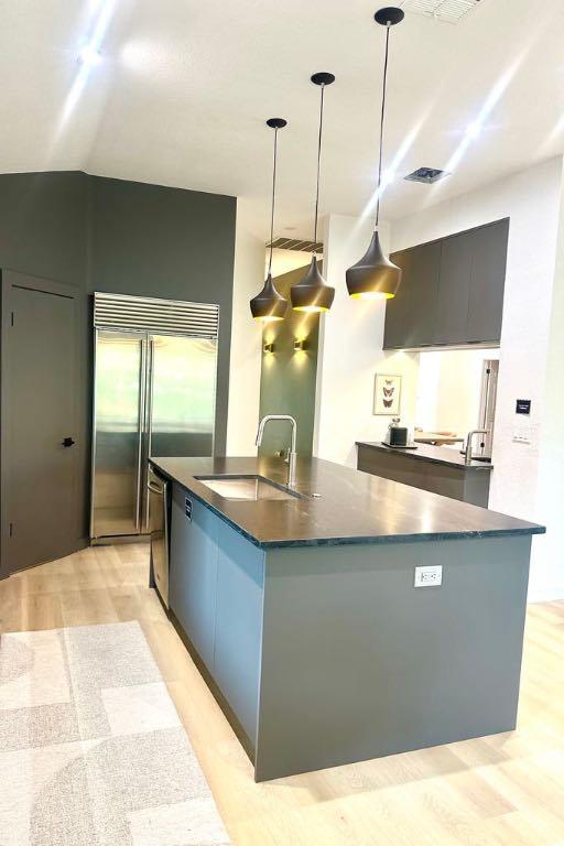 10825 Beachmont Ln, Austin, TX 78739 - kitchen with a sink, appliances with stainless steel finishes, a center island with sink, pendant lighting, and modern cabinets